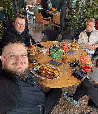 4 people smiling seated at a round table